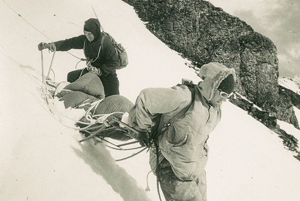1957 sur la face nord de l’Eiger : Lionel Terray et un collaborateur transportent le secouru Claudio Corti vers la vallée dans la luge de sauvetage conçue par Ludwig « Wimmerl » Gramminger.
